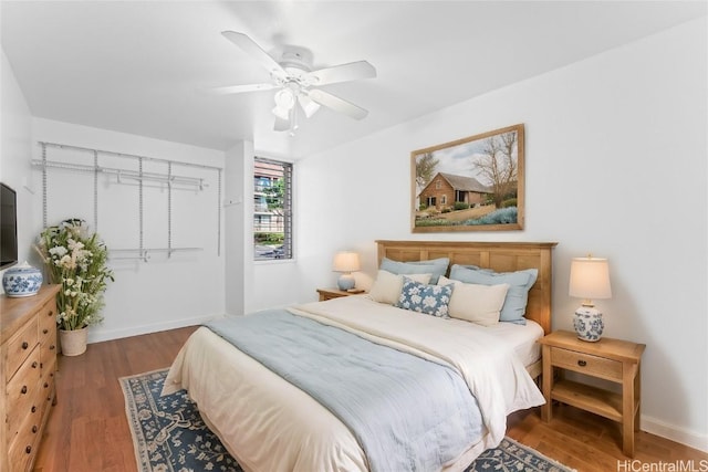 bedroom with ceiling fan, a closet, and dark wood-type flooring