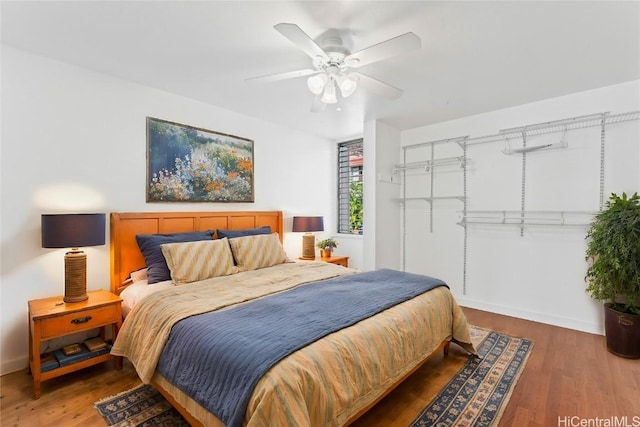 bedroom with dark hardwood / wood-style flooring and ceiling fan