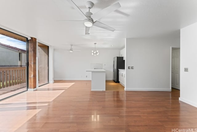 unfurnished living room featuring light hardwood / wood-style floors and ceiling fan with notable chandelier