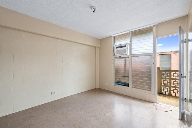 unfurnished room featuring cooling unit and a textured ceiling