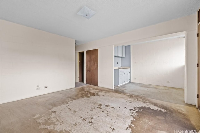 unfurnished bedroom featuring concrete flooring, sink, and ensuite bath