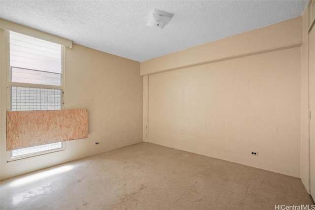 unfurnished room featuring a textured ceiling