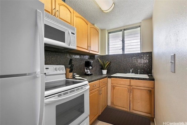 kitchen featuring white appliances, a textured ceiling, decorative backsplash, and sink