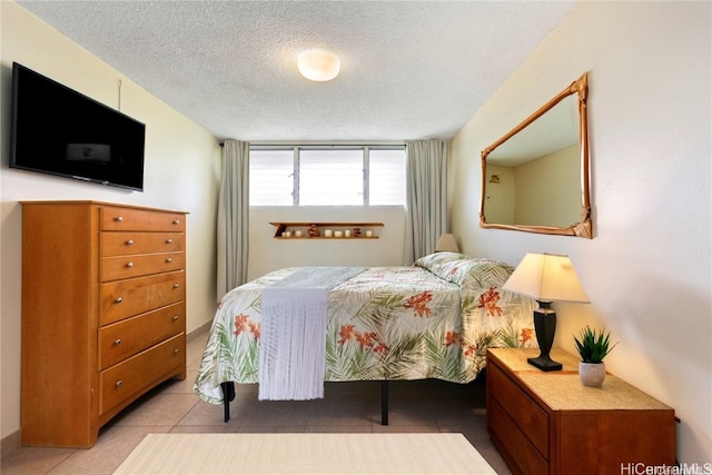 bedroom with a textured ceiling and light tile patterned floors