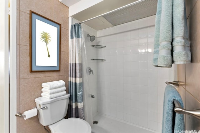 bathroom with toilet, tile walls, and curtained shower