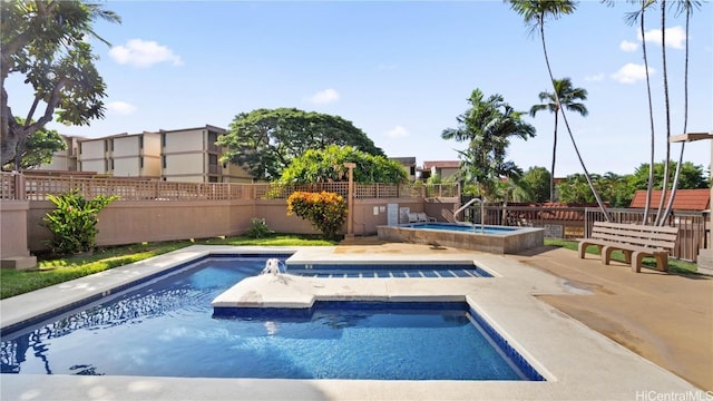 view of pool featuring fence, a fenced in pool, and an in ground hot tub