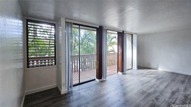 doorway to outside featuring dark wood-type flooring and a textured ceiling