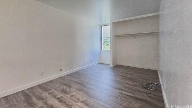 unfurnished bedroom featuring dark hardwood / wood-style flooring and a closet