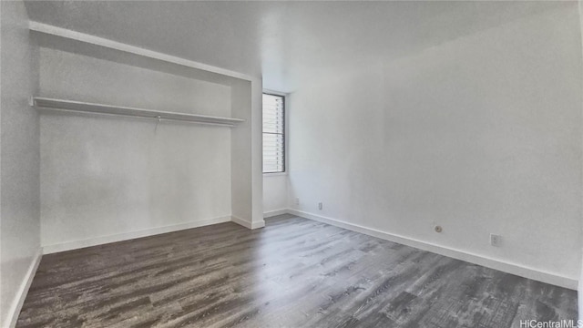 unfurnished bedroom featuring dark hardwood / wood-style flooring and a closet