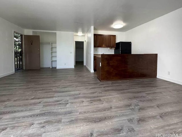 kitchen with baseboards, open floor plan, freestanding refrigerator, light countertops, and light wood-style floors