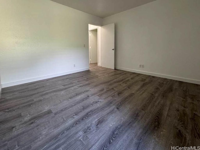 unfurnished room with dark wood-style flooring and baseboards