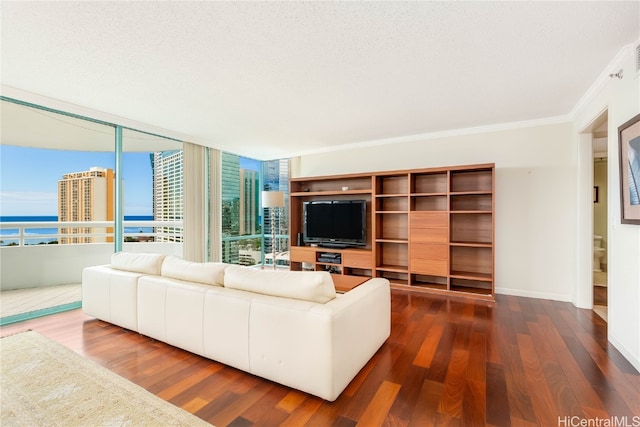 unfurnished living room featuring expansive windows, dark wood-type flooring, crown molding, a textured ceiling, and a water view