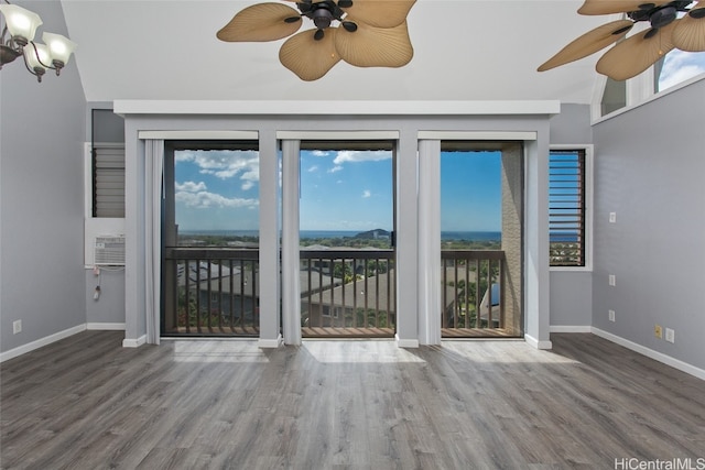 interior space featuring ceiling fan, wood-type flooring, vaulted ceiling, and a healthy amount of sunlight