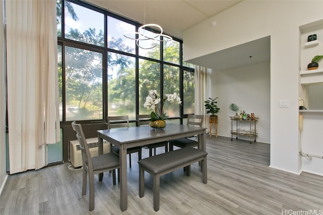 dining space featuring expansive windows, hardwood / wood-style flooring, and a chandelier