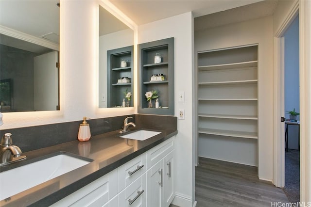 full bath featuring double vanity, a sink, and wood finished floors