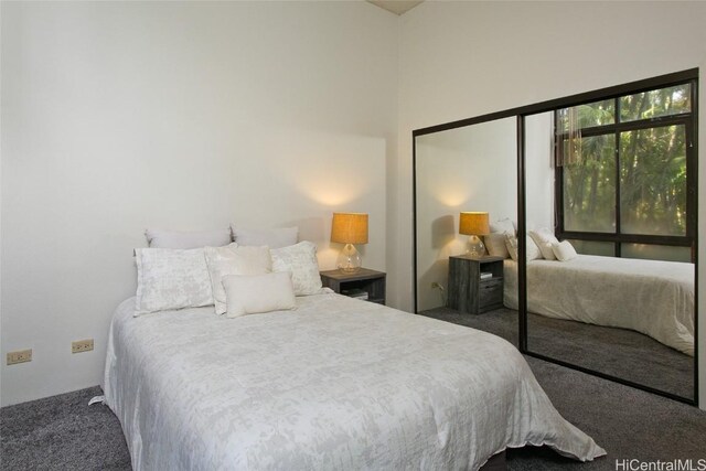 bedroom featuring a closet and dark carpet