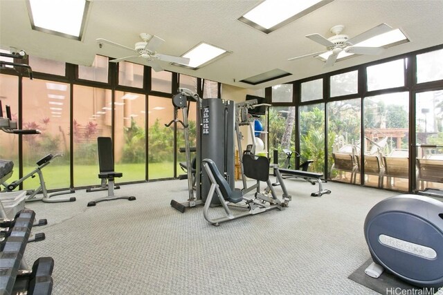 gym featuring floor to ceiling windows, carpet, a textured ceiling, and ceiling fan