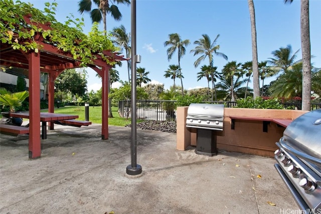 view of patio / terrace with fence, an outdoor kitchen, and area for grilling