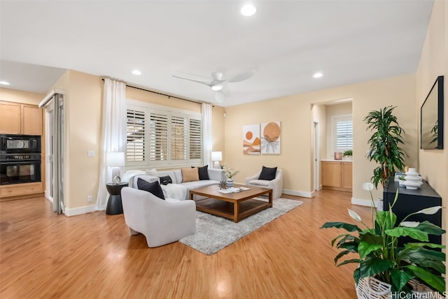 living room with light hardwood / wood-style floors and ceiling fan