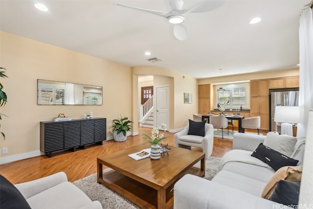 living room with ceiling fan and light hardwood / wood-style flooring