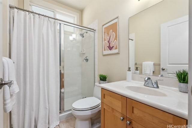 bathroom with a tile shower, tile patterned flooring, vanity, and toilet