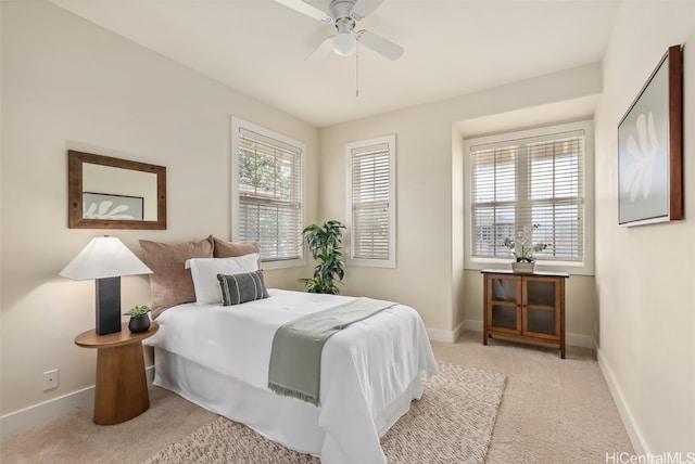 carpeted bedroom with ceiling fan and multiple windows