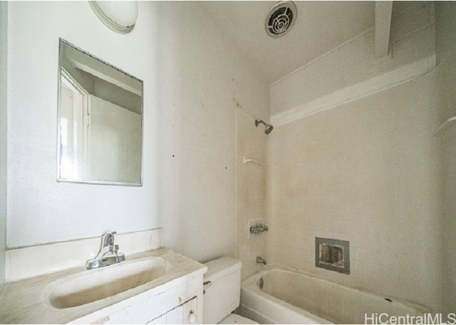 full bathroom with vanity, tiled shower / bath combo, and toilet