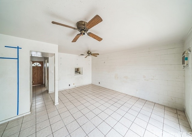 unfurnished room featuring brick wall, light tile patterned floors, and ceiling fan