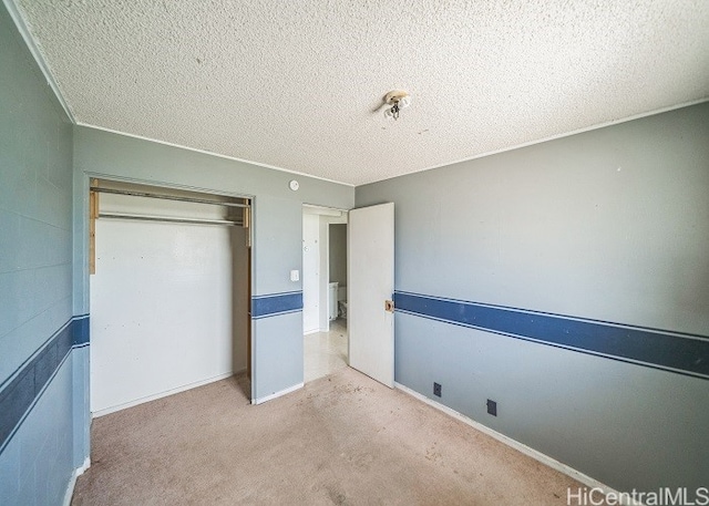 unfurnished bedroom featuring a closet, light carpet, and a textured ceiling