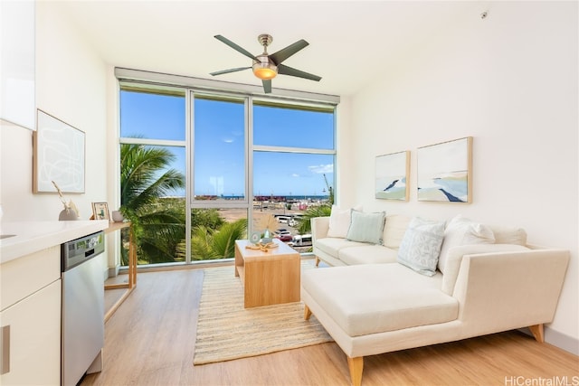 living room with ceiling fan, a healthy amount of sunlight, light hardwood / wood-style flooring, and floor to ceiling windows