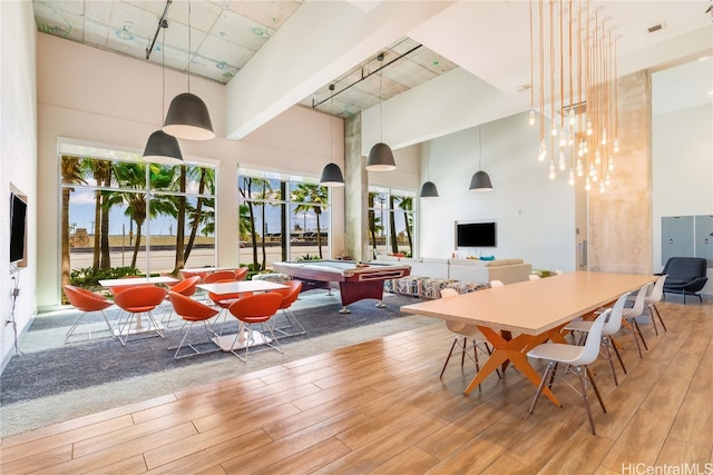 dining space featuring pool table, a high ceiling, and light wood-type flooring