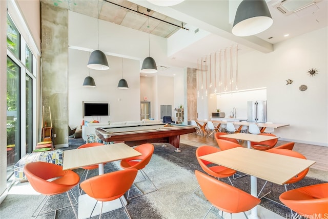 playroom featuring a towering ceiling, billiards, and wood-type flooring