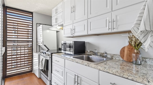 kitchen featuring appliances with stainless steel finishes, light hardwood / wood-style flooring, white cabinetry, and sink