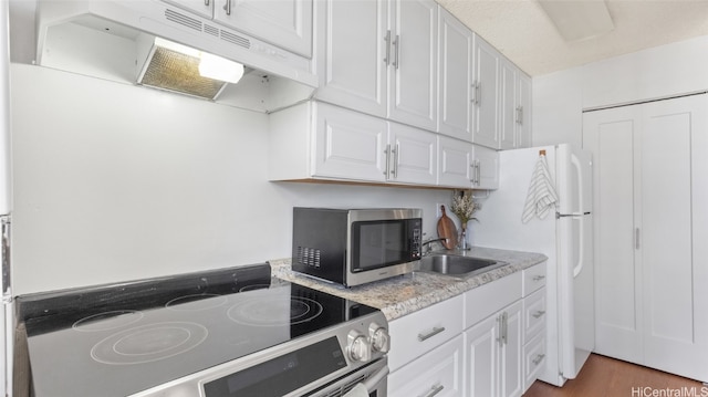 kitchen with appliances with stainless steel finishes, sink, dark hardwood / wood-style floors, and white cabinets