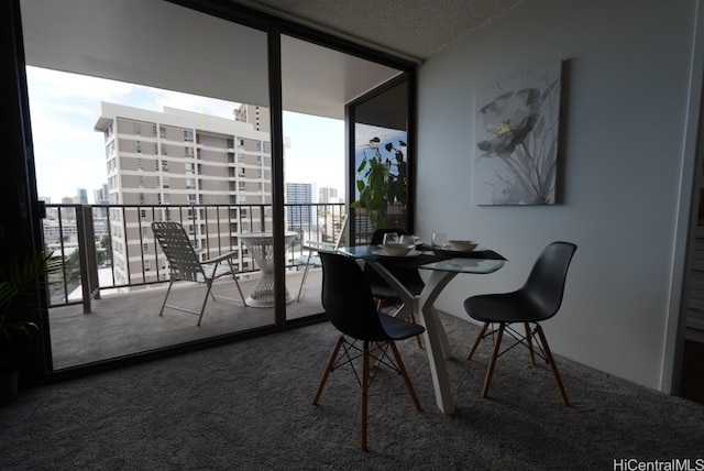 dining space featuring carpet flooring, expansive windows, a textured ceiling, and plenty of natural light