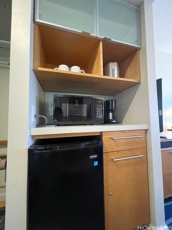 bar featuring refrigerator and black microwave