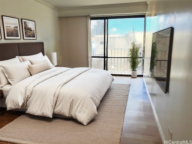 bedroom with baseboards, wood finished floors, and crown molding