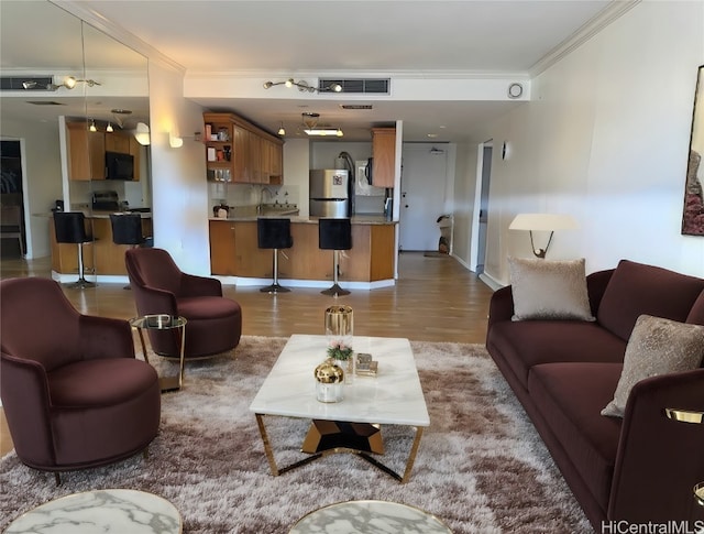 living room featuring light wood-type flooring and crown molding