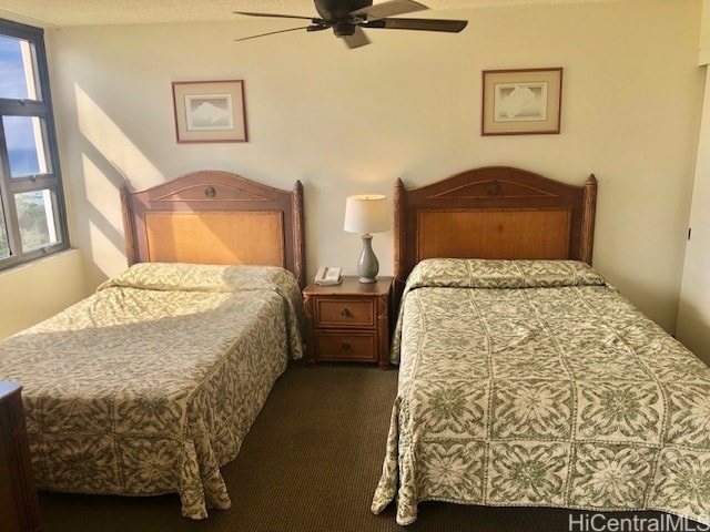 carpeted bedroom featuring a textured ceiling and ceiling fan