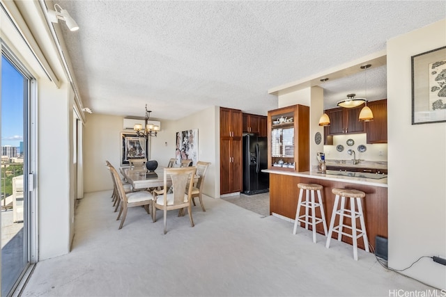 dining room with a wealth of natural light, a textured ceiling, and an inviting chandelier