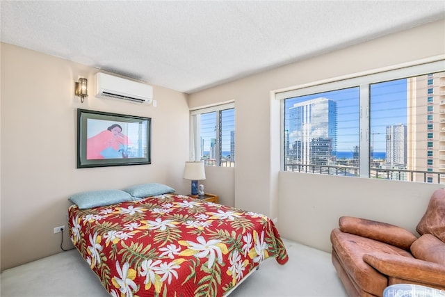 bedroom featuring an AC wall unit, a textured ceiling, and light colored carpet