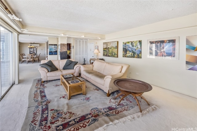 living room with carpet flooring, a textured ceiling, and an inviting chandelier