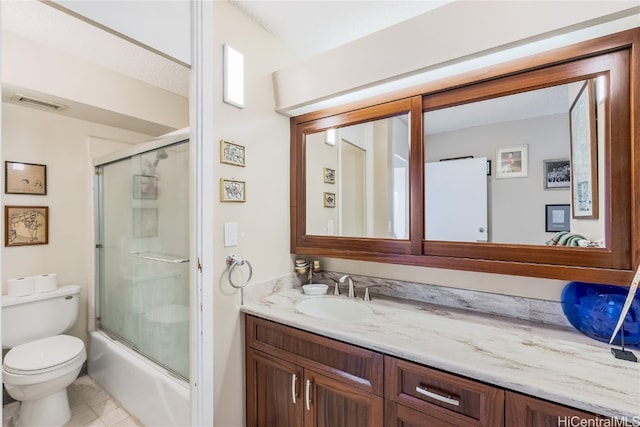 full bathroom with vanity, combined bath / shower with glass door, toilet, and tile patterned flooring