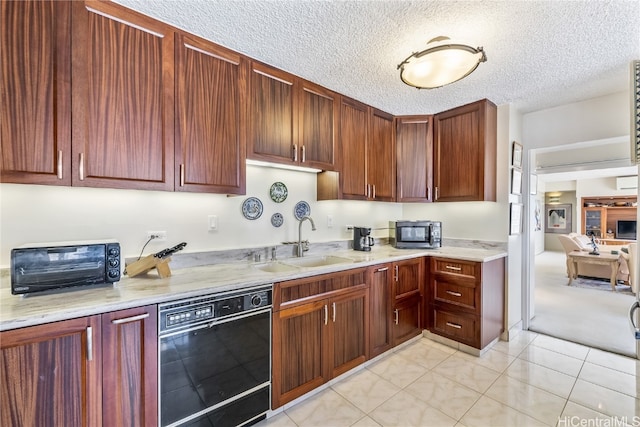 kitchen with light stone countertops, sink, dishwasher, a textured ceiling, and light carpet