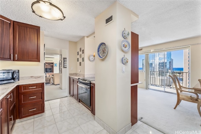 kitchen featuring a textured ceiling, light carpet, and stainless steel appliances