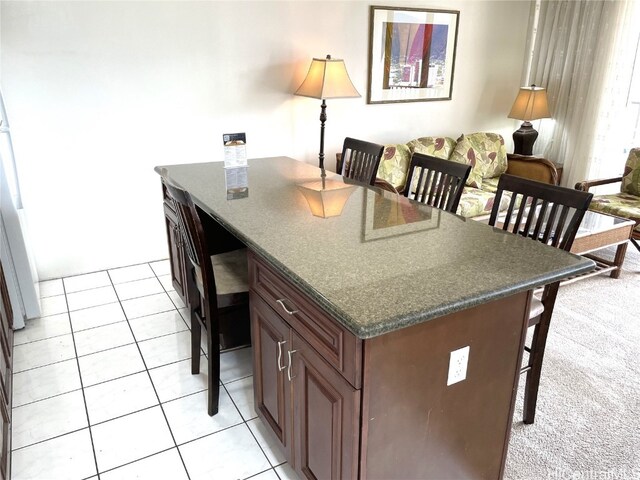 kitchen with a center island, dark stone counters, and light tile patterned floors