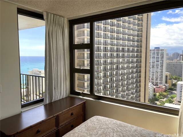 bedroom featuring a textured ceiling and a water view