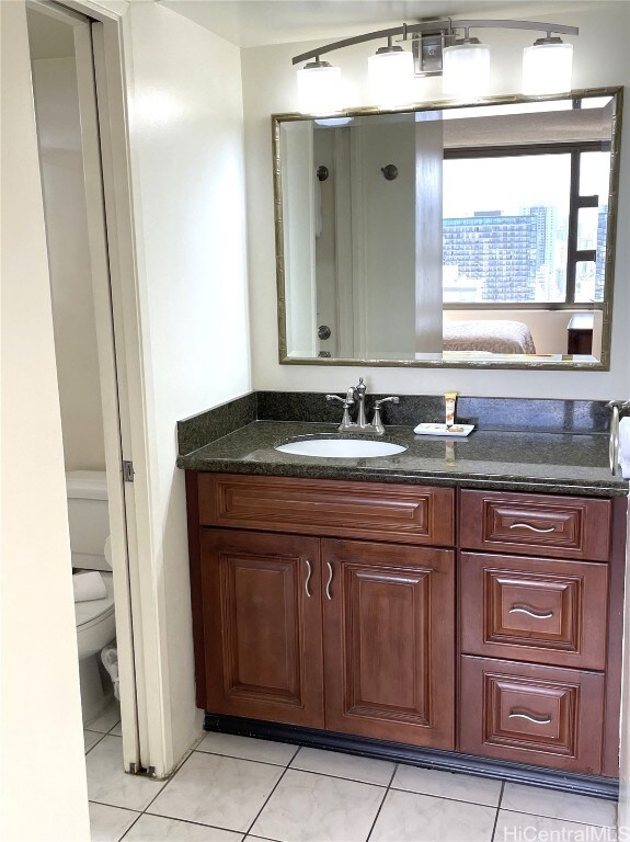 bathroom with vanity, toilet, and tile patterned floors