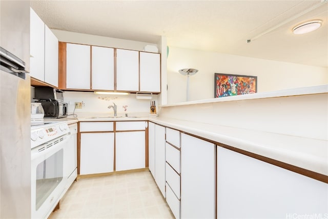 kitchen with white cabinets, range with electric stovetop, and sink