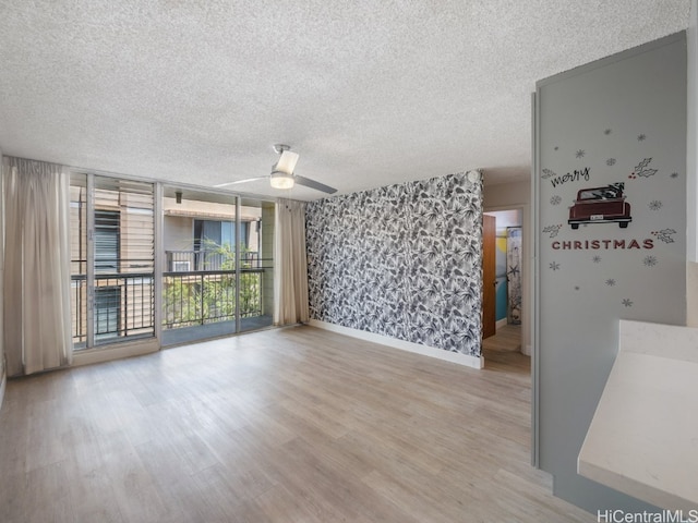 unfurnished room with ceiling fan, wood-type flooring, and a textured ceiling